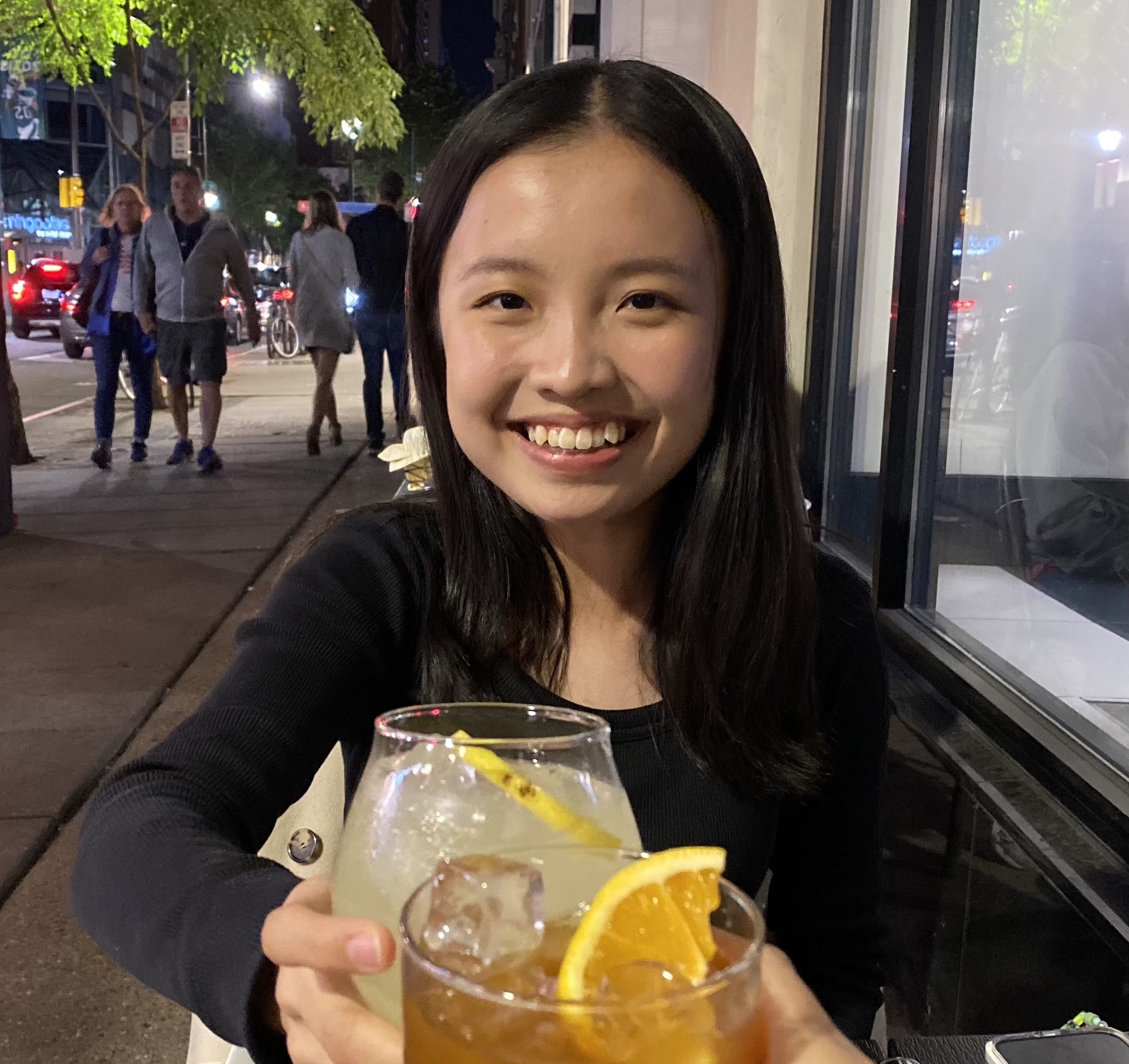 a photo of me in a black shirt, smiling and holding a beverage.